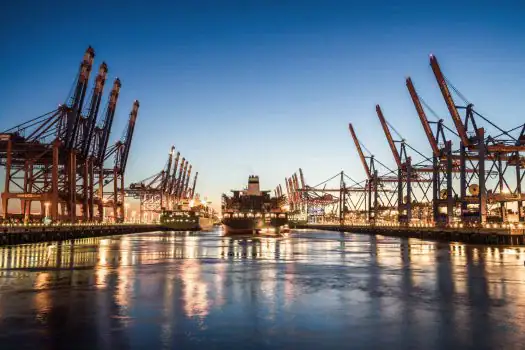 Containerhafen mit Kränen bei Sonnenuntergang, Hafenlogistik und Schifffahrt in Deutschland.